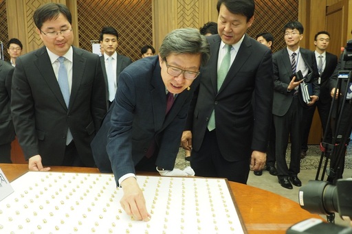박 총장이 제20대 국회의원 배지에 대한 설명을 듣고 있다. 