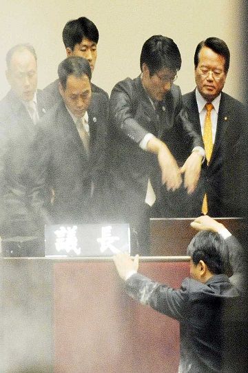 2011년 국회 본회의장에서 민노당 김선동 의원이 정의화 국회부의장(오른쪽)에게 최루가루를 뿌리자 경위들이 정 부의장을 보호하고 있다. 