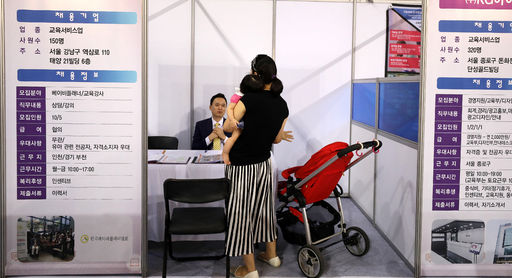13일 오후 인천 삼산월드체육관에서 열린 '2017 인천 여성 채용박람회'를 찾은 한 여성 구직자가 아이를 안은 채 구직상담을 받고 있다.