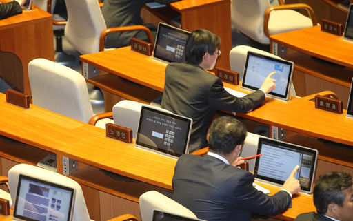 지난 2015년 12월 국회 본회의에 참석한 의원들이 손가락 터치를 통해 의석단말기를 사용하고 있다. 참석하지 않은 의원의 의석단말기에는 비밀먼호 입력창이 떠있다. 